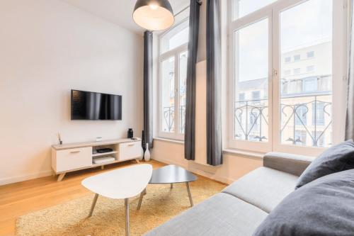 un salon avec un canapé et une télévision dans l'établissement Grand' Place - Beautiful apartment for 2, à Lille