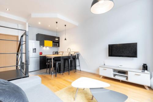 un salon avec une table et une cuisine dans l'établissement Grand' Place - Beautiful apartment for 2, à Lille