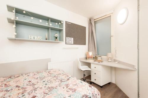 a bedroom with a bed and a desk and a mirror at Cosy Private Ensuites and Studios in the heart of Cheltenham in Cheltenham