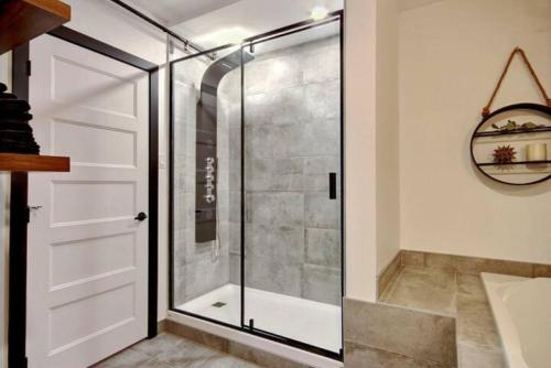 a shower with a glass door in a bathroom at Deluxe Estate // Two in One Downtown Québec City in Quebec City