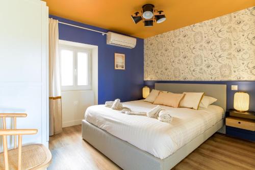 ein Schlafzimmer mit einem großen Bett mit blauen Wänden in der Unterkunft SELECT'soHOME - Bel appartement rénové idéalement situé au coeur du Lavandou et de ses animations ! - MARINA-5 in Le Lavandou