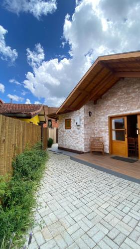 a house with a patio and a fence at Chalés Bella in Monte Verde