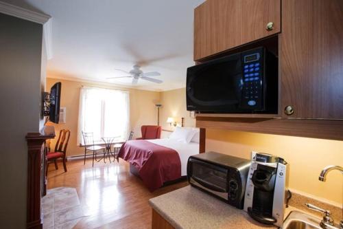 a hotel room with a bed and a microwave at Relais St-Denis in Saint-Sauveur-des-Monts