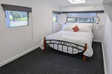 um pequeno quarto com uma cama numa pequena casa em The Traveller Escape at Grampians Edge em Dadswells Bridge