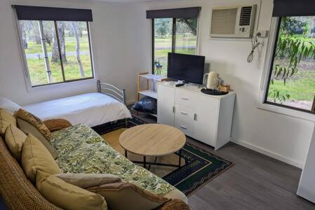 a living room with a couch and a table and a bed at The Traveller Escape at Grampians Edge in Dadswells Bridge