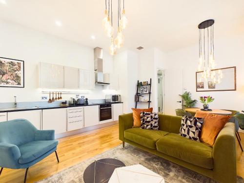 ロンドンにあるBe London - Covent Garden Apartmentsのリビングルーム(緑のソファ付)、キッチンが備わります。