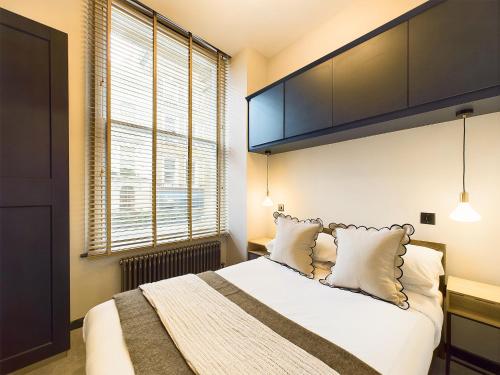 a bedroom with a large bed with white sheets and pillows at Be London - Covent Garden Apartments in London