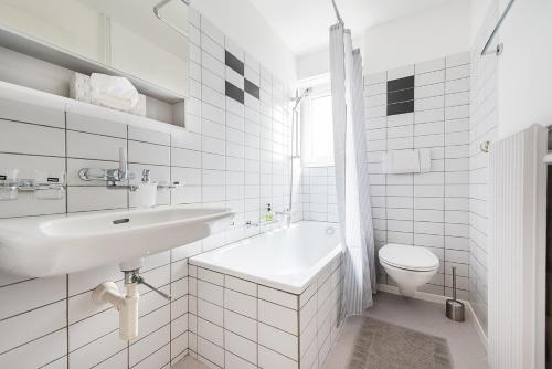 La salle de bains blanche est pourvue d'un lavabo et de toilettes. dans l'établissement Cooldis 13 (Gratis Parken, Free Parking), à Kreuzlingen