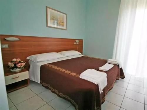 una camera con un grande letto con testiera in legno di acapulco hotei a Rimini