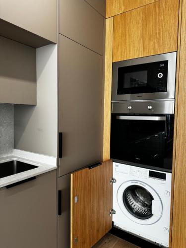 a kitchen with a washing machine and a microwave at Reyes Católicos Premium Beach, Playa Urbanova, Alicante in Alicante