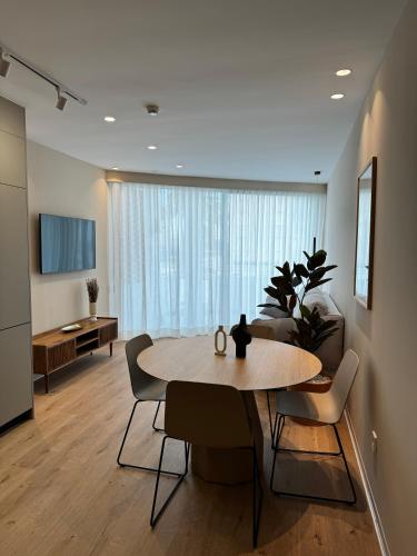 a room with a table and chairs and a living room at Reyes Católicos Premium Beach, Playa Urbanova, Alicante in Alicante