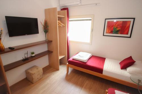 a small room with a bed and a flat screen tv at Villa Deny Mostar - with free parking in Mostar