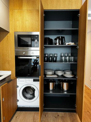 a kitchen with a washing machine and a microwave at Reyes Católicos Premium Beach, Playa Urbanova, Alicante in Alicante