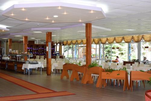 uma sala de jantar com mesas e cadeiras num restaurante em Balaton Hotel em Sunny Beach