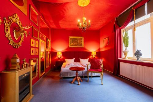 a bedroom with red walls and a bed and a table at LaLeLu Hostel Dresden in Dresden