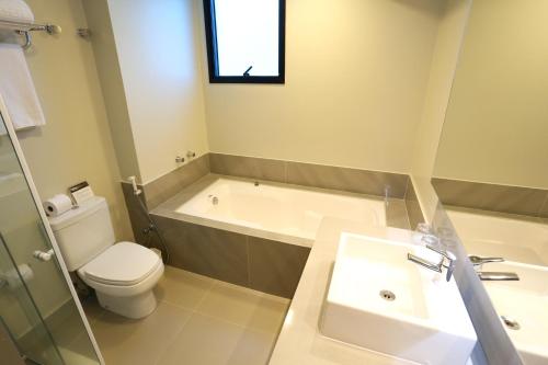 a bathroom with a tub and a toilet and a sink at Blue Tree Premium Florianópolis in Florianópolis