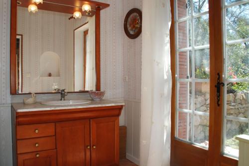 baño con lavabo, espejo y ventana en Le BASTIDON de CHANTE PIERRE, en Cuers