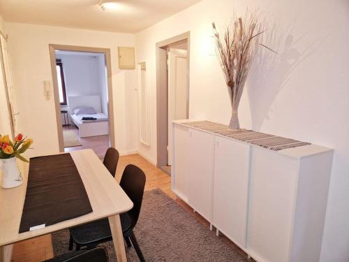 een eetkamer met een tafel en een witte kast bij Nordseeluft Apartment in Bremerhaven
