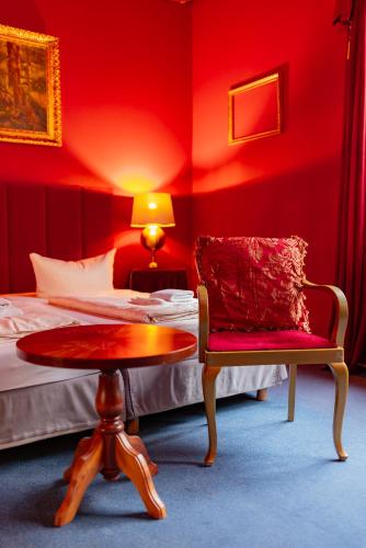 a red room with a bed and a table and a chair at LaLeLu Hostel Dresden in Dresden
