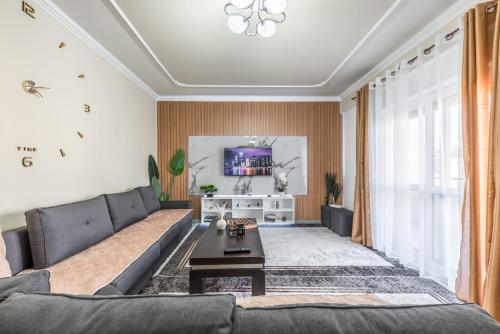 a living room with a couch and a tv at Full Sea View Center 2 Bedroom in Durrës
