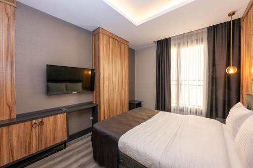a bedroom with a bed and a flat screen tv at The Nirvanas Hotel in Istanbul