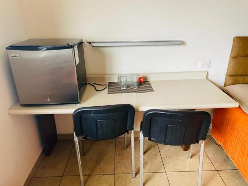 uma mesa com duas cadeiras e um portátil em Hotel las Palmas em Hermosillo