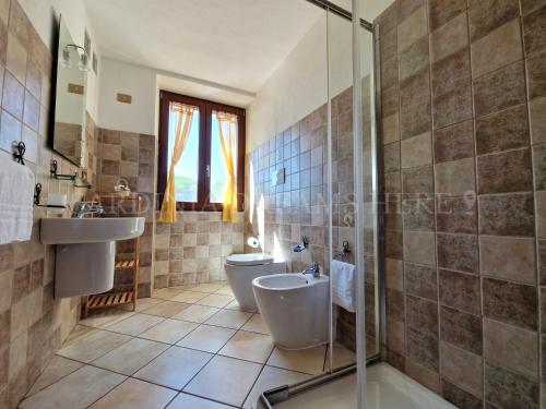 a bathroom with two sinks and a toilet and a shower at Villetta Meraviglia a 100 m dalla spiaggia in Vignola Mare