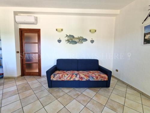 a blue couch sitting in a room at Villetta Meraviglia a 100 m dalla spiaggia in Vignola Mare