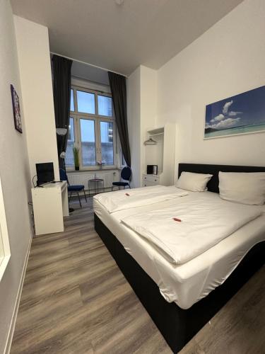 a bedroom with a large white bed in a room at Hotel Astor in Wuppertal