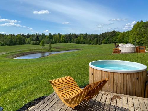 une chaise assise sur une terrasse à côté d'un bain à remous dans l'établissement 4rest Camp, à Pawłowo