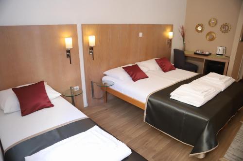 a hotel room with two beds and two tables at Villa Deny Mostar - with free parking in Mostar