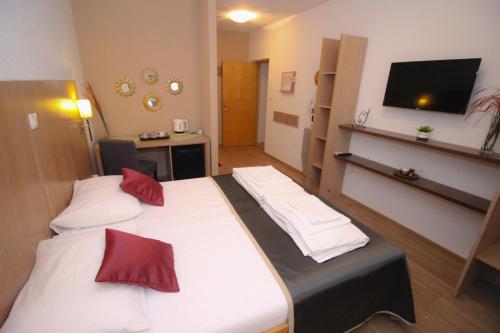 a hotel room with two beds and a flat screen tv at Villa Deny Mostar - with free parking in Mostar
