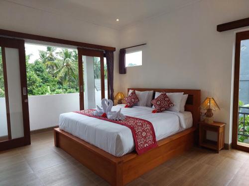 een slaapkamer met een groot bed met rode kussens bij Prema Shiva Suites and Villas by EPS in Ubud