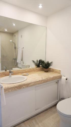 une salle de bain avec un lavabo et un miroir dans l'établissement Cannes Marina, T3 vue Mer, Piscine, By Palmazur, à Mandelieu-la-Napoule