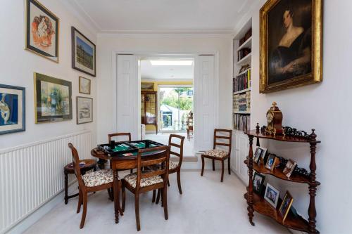 a dining room with a table and chairs at Veeve - The Gallery of Colour in London