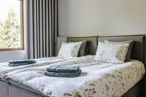 un letto con cuscini sopra in una camera da letto di Uus-Meremäe Kadaka Villa with Jacuzzi, Golf & Padel a Pivarootsi