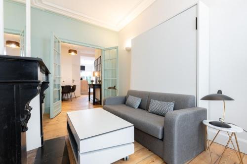 een woonkamer met een bank en een tafel bij Vieux Lille - Nice studio with terrace in Lille
