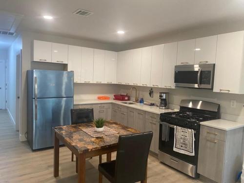 a kitchen with a table and a blue refrigerator at King Suite 8Mins to Newark Airport in Newark
