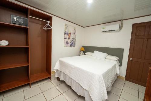 a small bedroom with a bed and a closet at Hotel Tortuguero Beachfront in Tortuguero