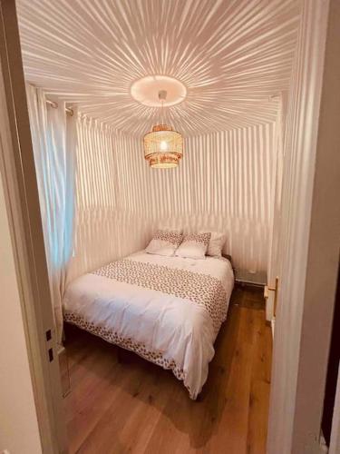 Cama pequeña en habitación con lámpara de araña en Sublime Rooftop Cinq-Avenues Longchamp en Marsella