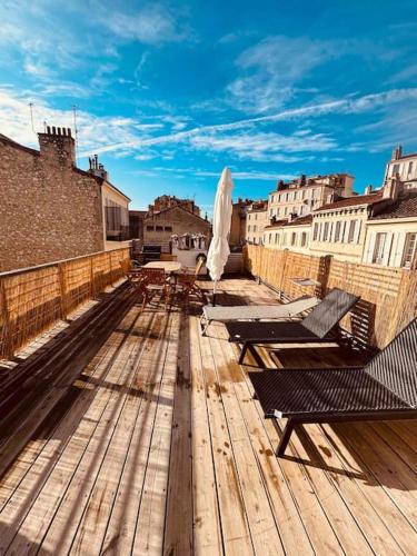 une terrasse en bois avec bancs au-dessus d'un bâtiment dans l'établissement Sublime Rooftop Cinq-Avenues Longchamp, à Marseille