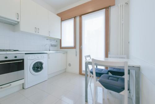 eine Küche mit einer Waschmaschine und einem Tisch in der Unterkunft QUEEN HOME GEMMA in Mestre