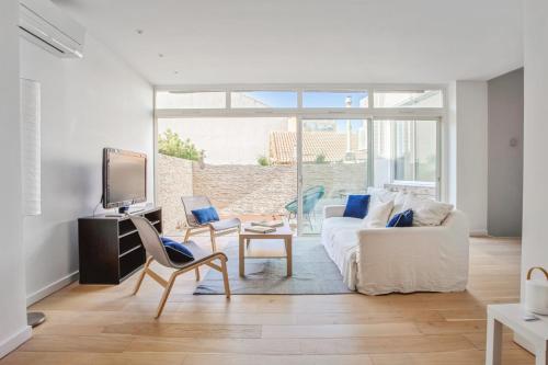 Apartment near the sea in Marseille - Welkeys في مارسيليا: غرفة معيشة مع أريكة بيضاء وتلفزيون