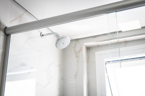 a shower with a shower head next to a window at Hotel Kindermann in Caçador
