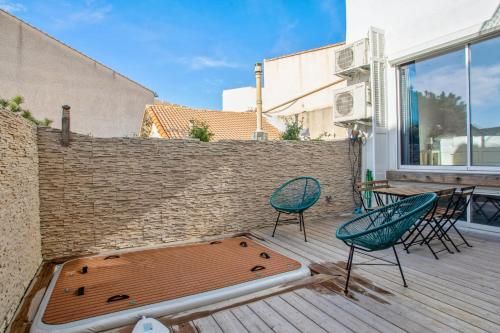 Apartment near the sea in Marseille - Welkeys في مارسيليا: سطح مع كراسي وحوض استحمام ساخن في الفناء