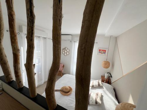 - une chambre avec un lit entouré de troncs d'arbres dans l'établissement Très bel appartement pour 3 avec piscine, à La Londe-les-Maures