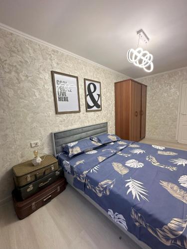 a bedroom with a bed with a blue comforter at Fresh and cozy apartmrent in Yakkasaray