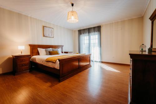 duża sypialnia z łóżkiem i oknem w obiekcie A Nossa Casa w mieście Castelejo