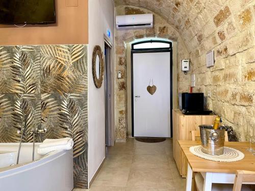 a bathroom with a tub and a table and a door at Casa Vacanze A un Passo dal Volo in Bari