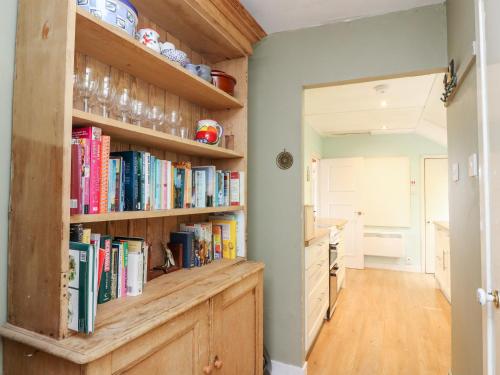 a kitchen with a book shelf filled with books at Waterfall Cottage in Aberfeldy